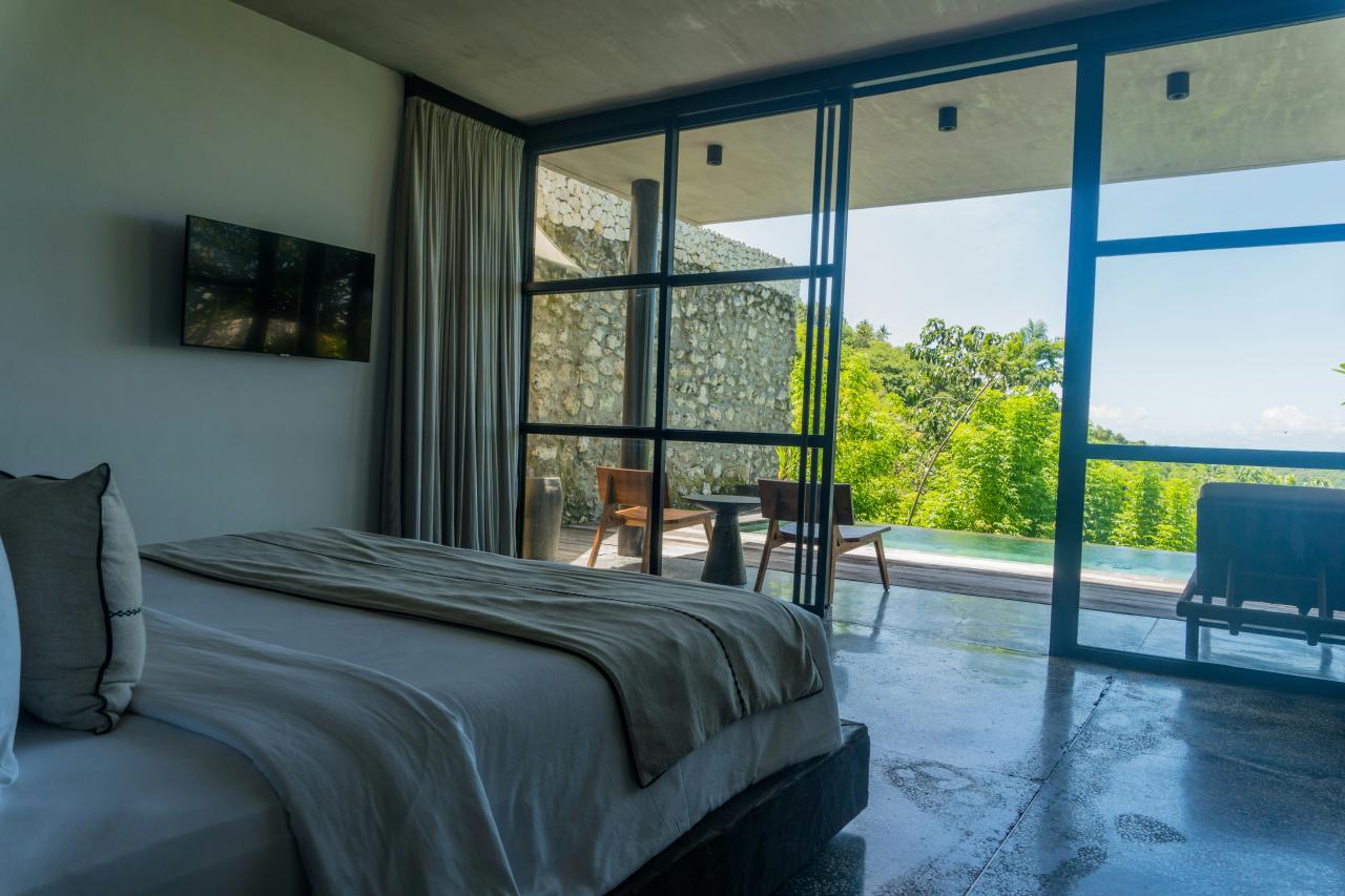 A bedroom with a large bed and a sliding glass door