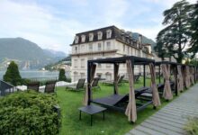 A large building with a lawn and picnic tables in front of it