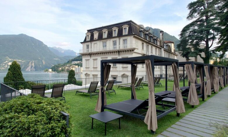 A large building with a lawn and picnic tables in front of it