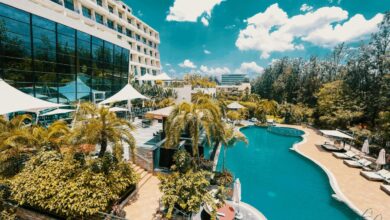 white and blue concrete building near green trees and body of water during daytime