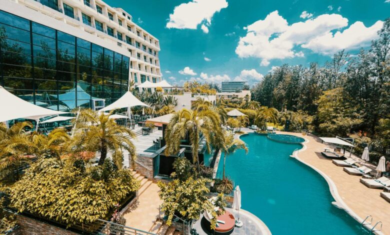 white and blue concrete building near green trees and body of water during daytime